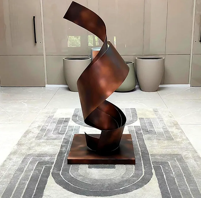 Copper ribbon sculpture on a plinth