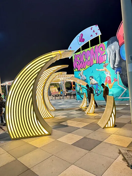 Giant lit crescent arches at a festival entrance