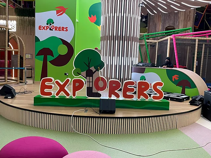 Kids stage with Explorers branding in a mall