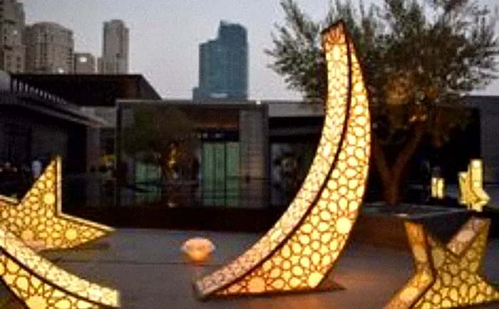 Lit patterned crescent and stars at a waterfront venue